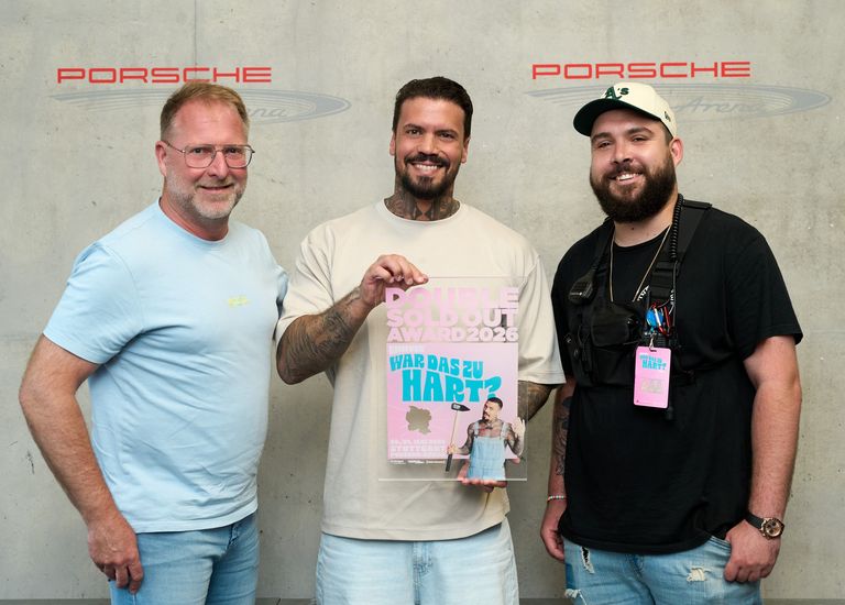 Gruppenfoto mit drei Personen, in der Mitte Emmvee, der den Award in den Händen hält. Links steht René Otterbein (in.Stuttgart Veranstaltungsgesellschaft), rechts Sascha Schmitz (Projektleiter Meyer-Konzerte).