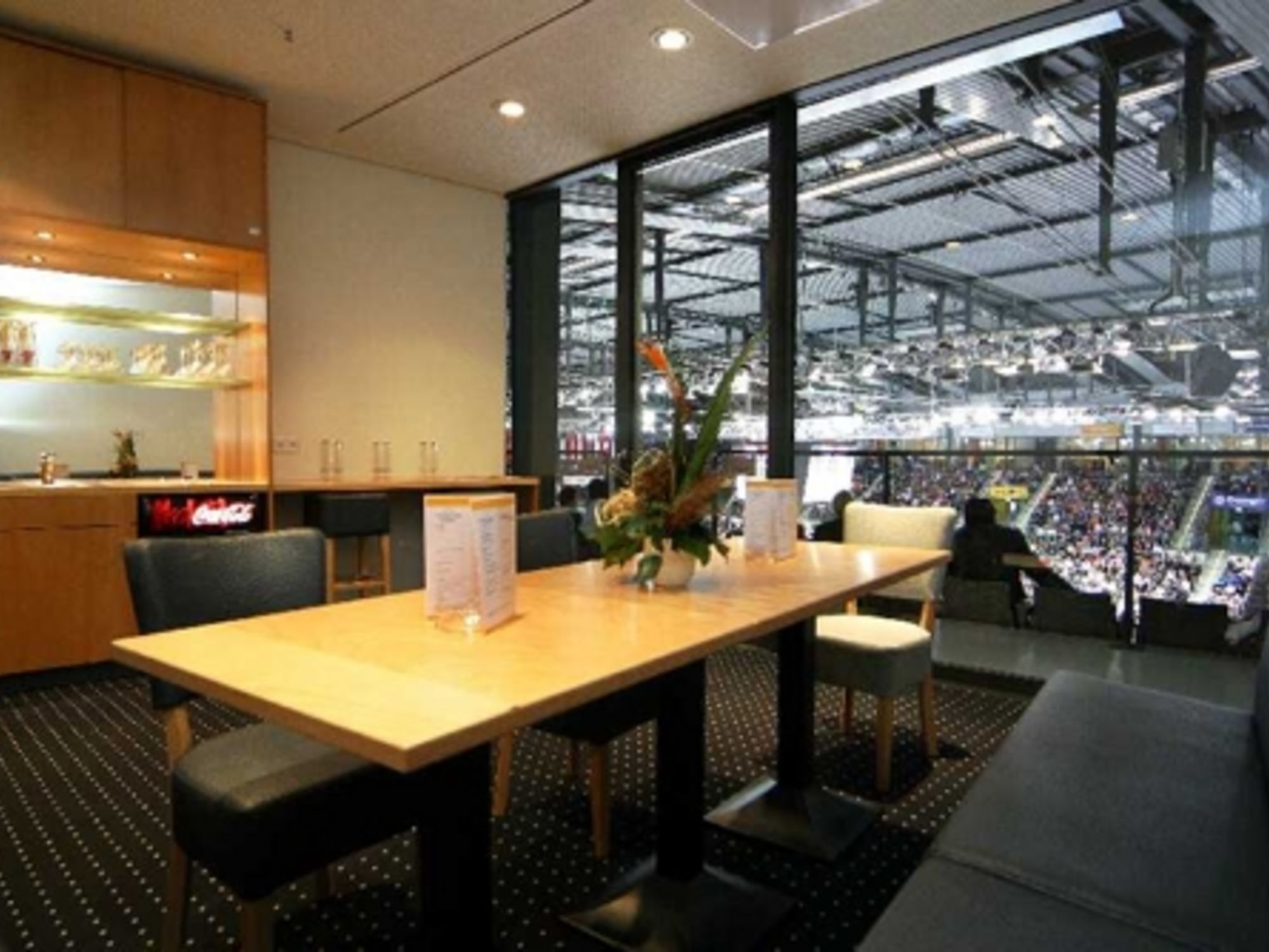 Blick in eine Loge der Porsche-Arena mit Tisch, Stühlen und Holzoptik an den Wänden