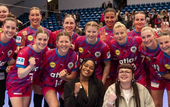 [Translate to Englisch:] Mannschaftsfoto der Deutschen Handball Nationalmannschaft der Frauen mit den beiden Musikerinnen Bria und Lucille