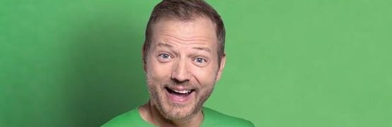Mario Barth vor einem grünen Hintergrund, lächelt in die Kamera