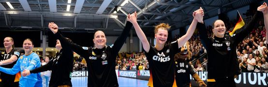 Nationalspielerinnen halten sich an den Händen und halten diese in die Höhe. Große Freude in ihren Gesichtern.