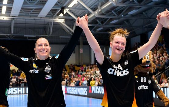 Nationalspielerinnen halten sich an den Händen und halten diese in die Höhe. Große Freude in ihren Gesichtern.