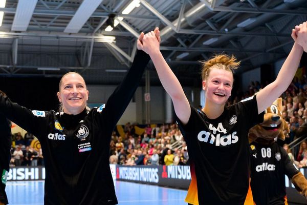 [Translate to Englisch:] Nationalspielerinnen halten sich an den Händen und halten diese in die Höhe. Große Freude in ihren Gesichtern.