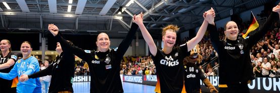 Nationalspielerinnen halten sich an den Händen und halten diese in die Höhe. Große Freude in ihren Gesichtern.